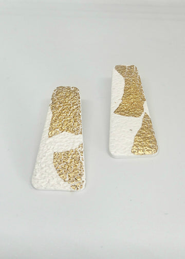 Pair of gold and white handmade polymer clay earrings  on a light gray background