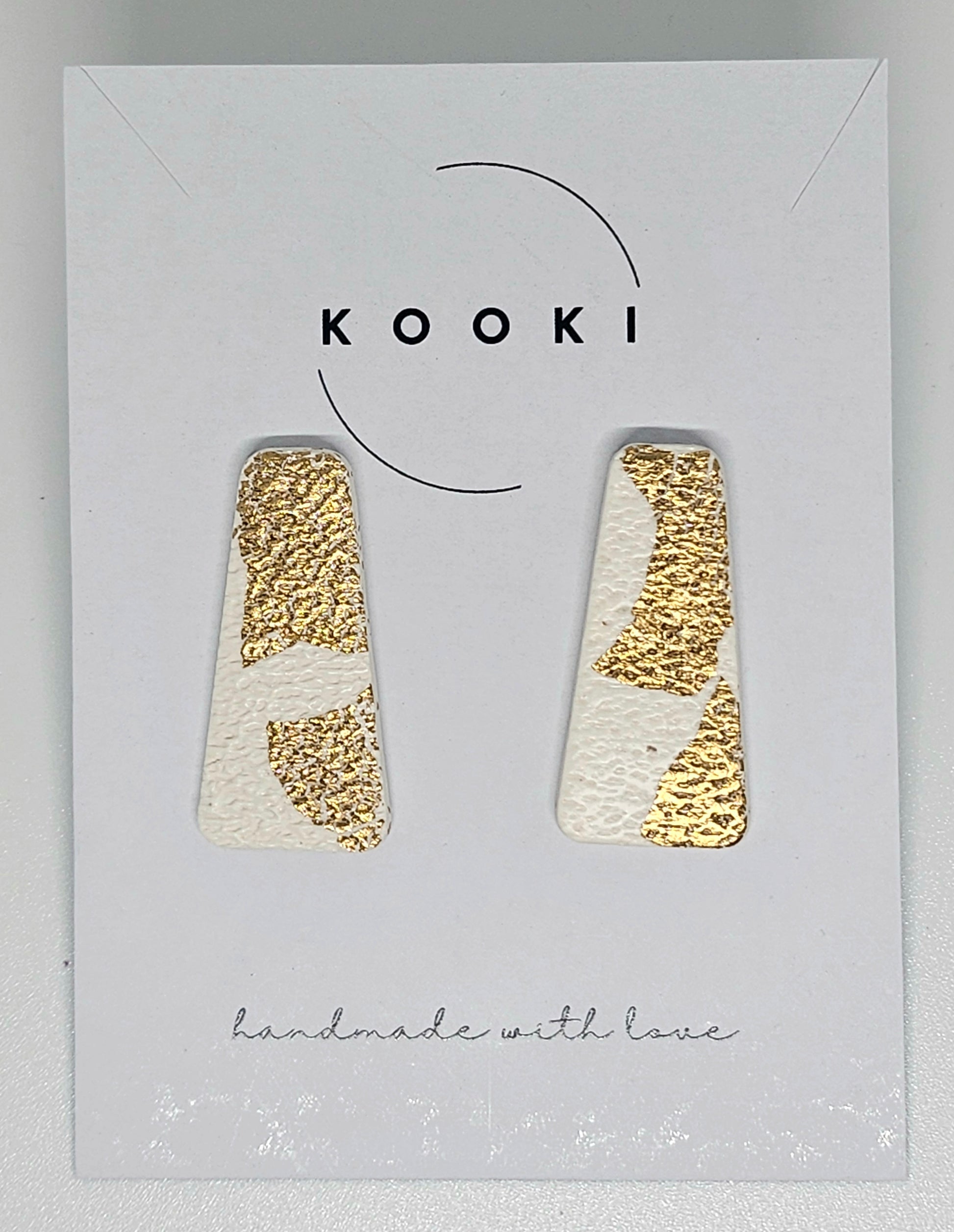 Pair of gold and white  handmade polymer clay earrings  on a Kooki branded card.
