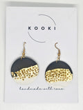 Kooki handmade polymer clay earrings on a white card with festive gold and black design
